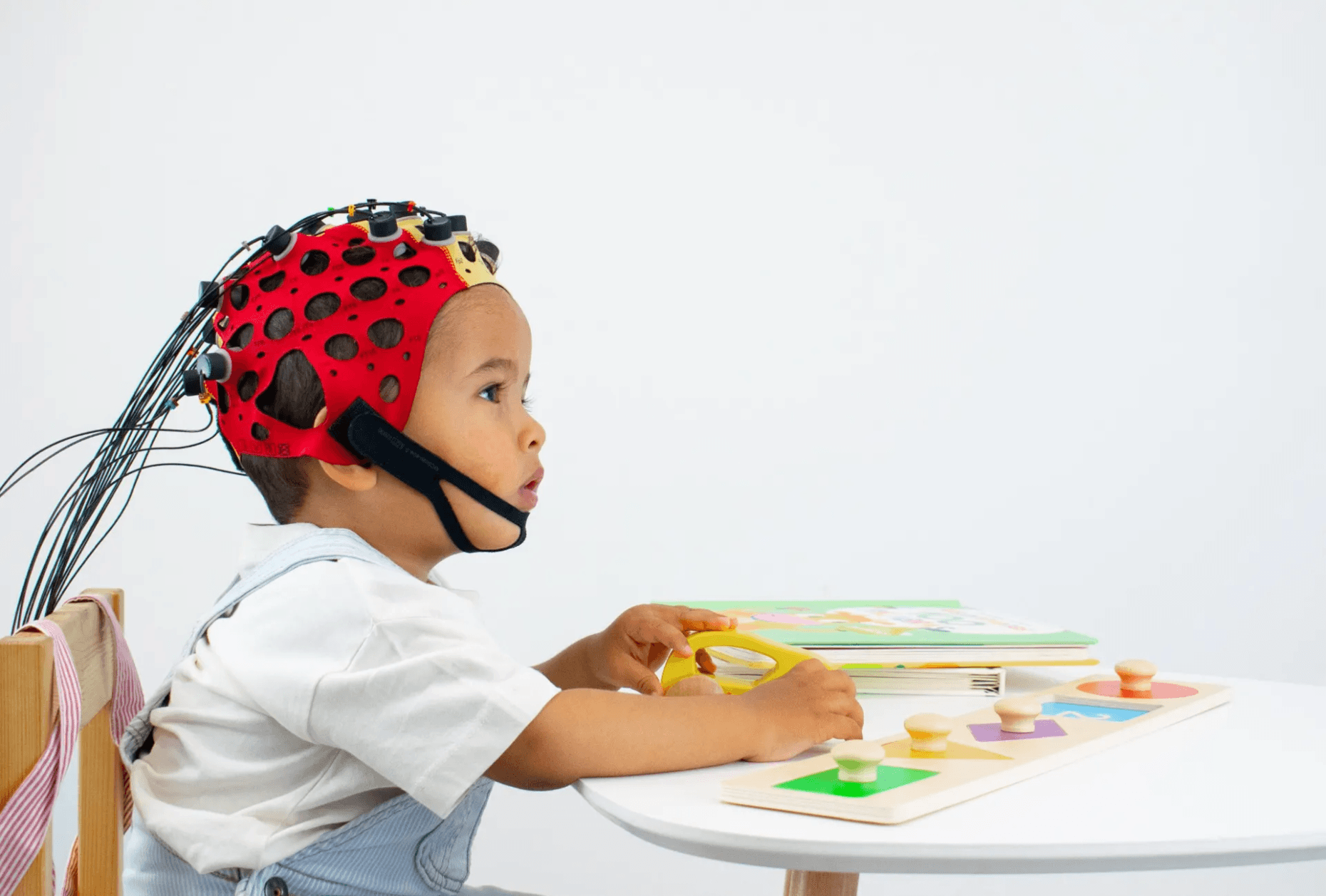 Child wearing the Bitbrain Versatile EEG Kids system for brain activity monitoring during a cognitive assessment or training activity.