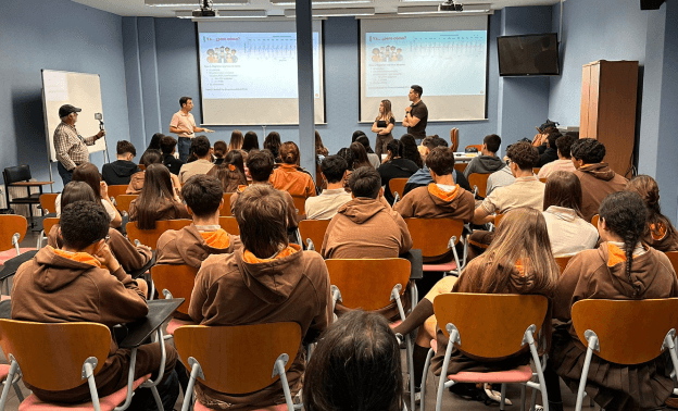 Students attending an educational EEG demonstration in a classroom, where presenters explain how the P300 brain signal can be used to detect attention and stimulus recognition.