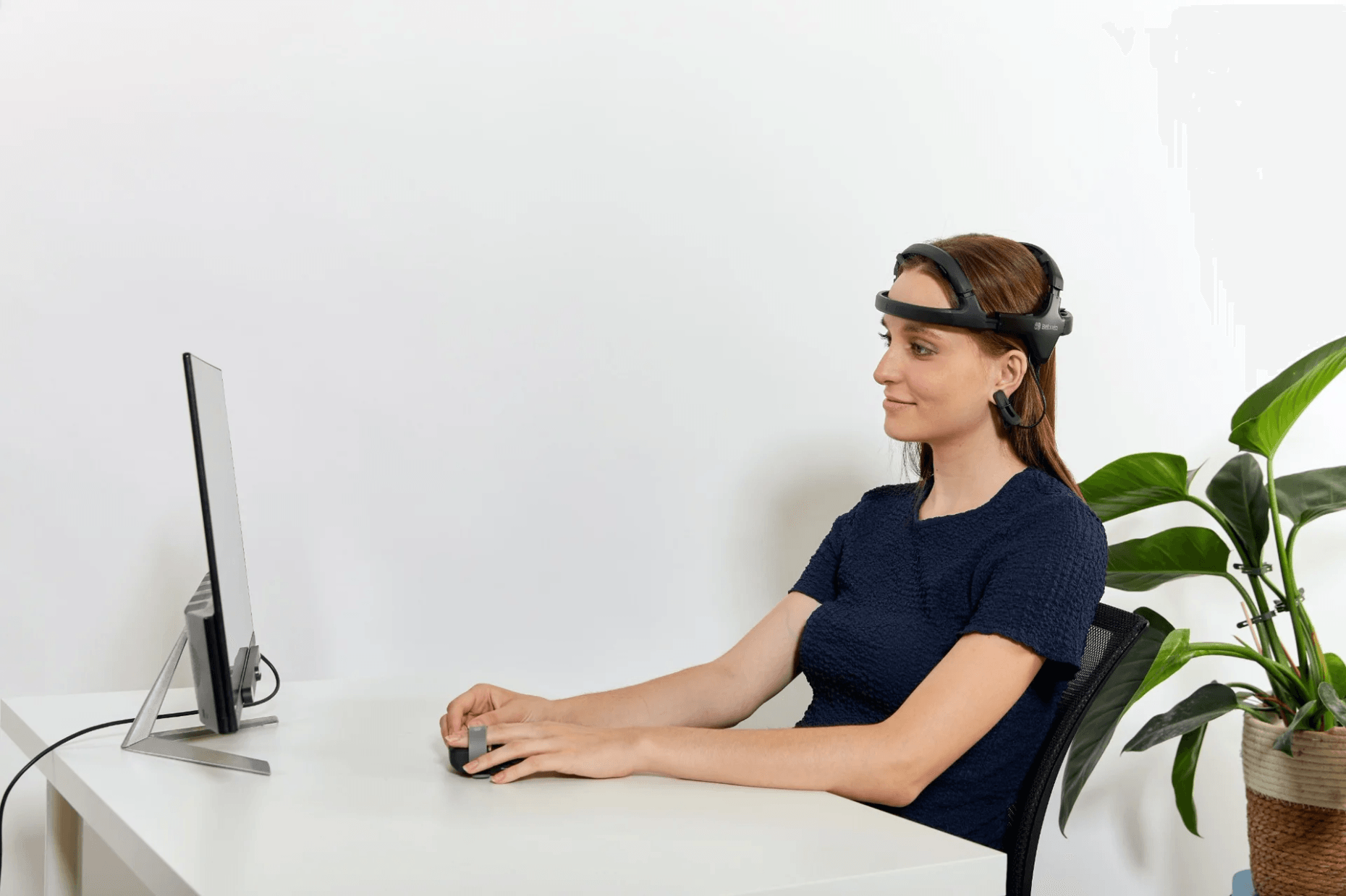 Participant using Bitbrain Diadem dry-EEG and Ring biosignal amplifier while viewing a computer screen with Tobii Spark screen-based eye tracking for multimodal human behavior research.